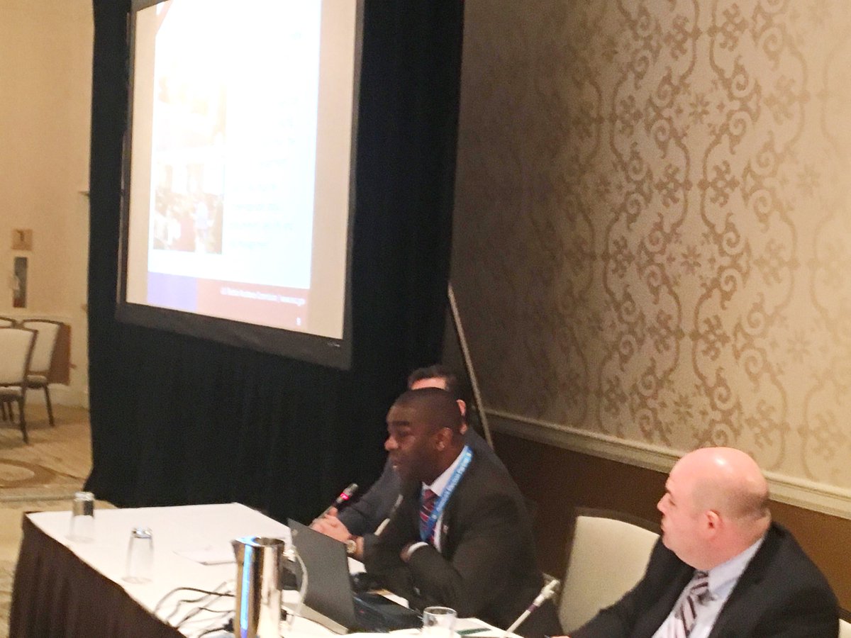 3 people from EAC sitting at the front of the room. Giving an update to attendees.