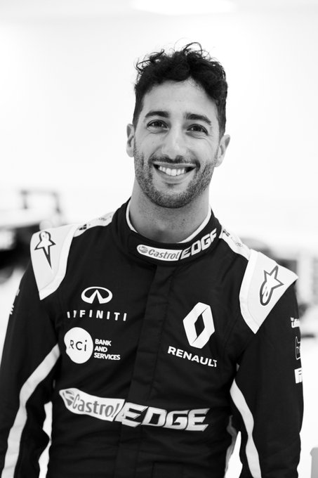 Daniel in overalls at Enstone. He's smiling.