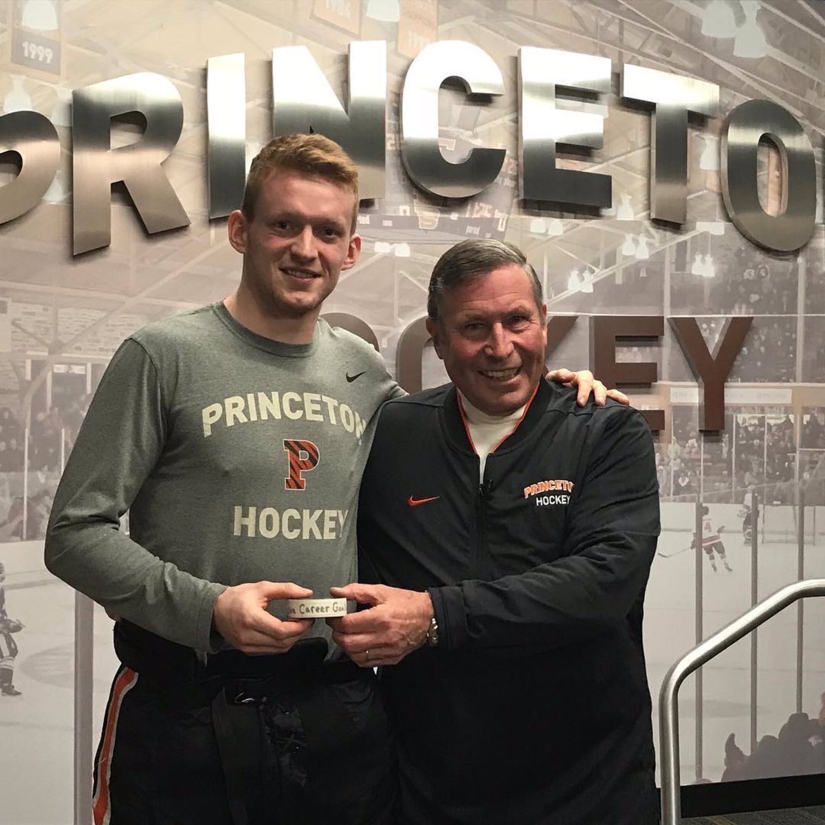 princetonhockey's tweet photo. John Cook ‘63 passes the puck to Ryan Kuffner as Kuffner surpassed Cook’s 56-year record in all-time goals with 68 #sticktaps #programfirst @Princeton history @ncaaicehockey @ecachockey https://t.co/U0OL3HG1H4