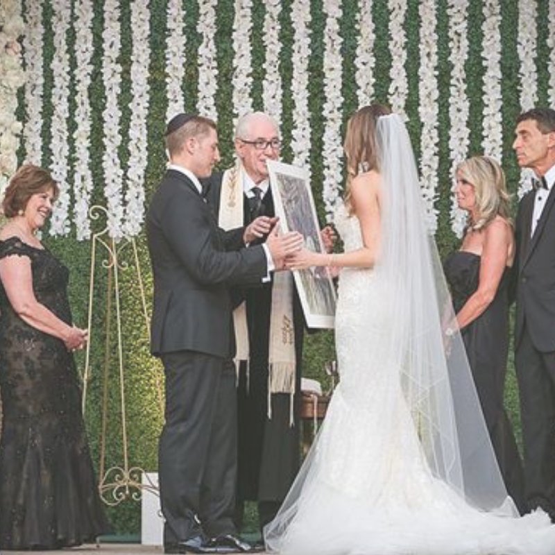 Michele and Scott went all out for their wedding dripping in white orchids. Scott hands Michele their Gravity Of Love Ketubah but you have to see the entire feature on @smashingtheglass