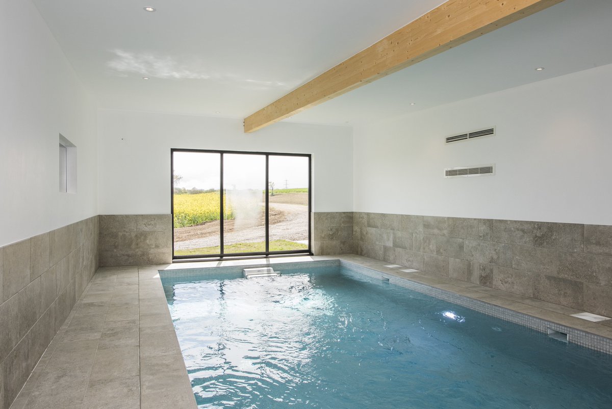 SuffolkEscape's tweet photo. It's a little blustery outside...perhaps today is a pool day?! Our Sheepyard Barn has a Fastlane Counter Current Swim Machine to swim against with stunning views of the countryside ahead #relax #swim #endlesspool #fitness #indoorpool #holidaybarn #suffolkholiday #unwind https://t.co/AOiT5hr4yR