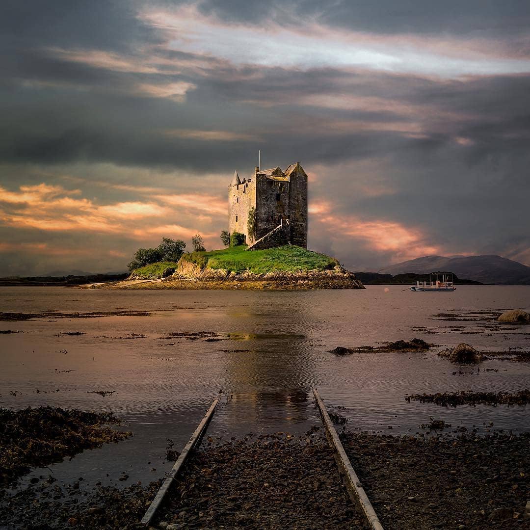VisitScotland's tweet photo. Castle Stalker with a stormy backdrop = Perfection! 🧡👌 #WildAboutArgyll 📍 Appin, #Argyll 📷 IG/bradhyd https://t.co/y93KMQ8PGB
