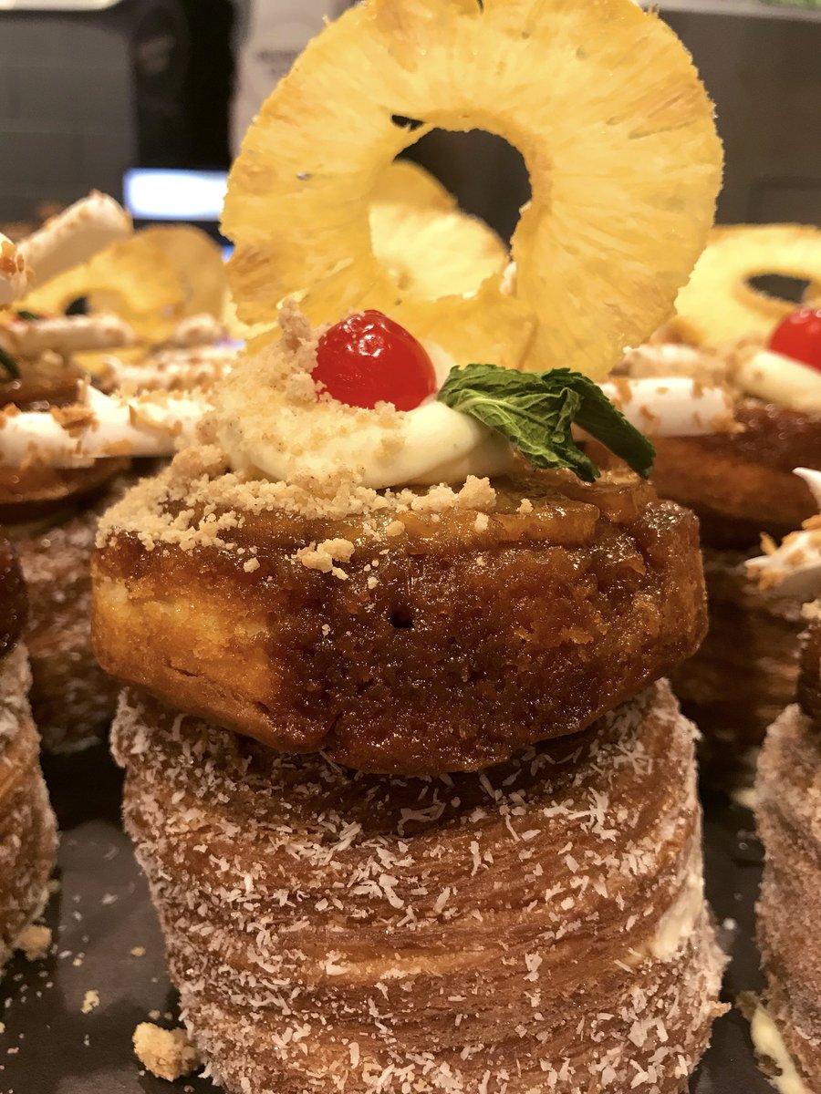 CRAZY KRONUT THURSDAY!! 
🥥 🍹❤️

Rolled in coconut sugar, filled w/ coconut rum cream, topped w/ an upside down pineapple cake, toasted meringue sticks, pineapple crisp, maraschino cherry and cookie crumble!!