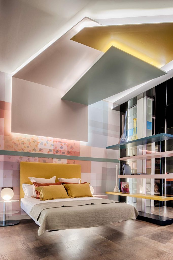#WelcomeDesign proyecta en #CasaDecor2019 este colorido dormitorio con zona de lectura para <a href="/lagodesign/">LAGO DESIGN</a>. Las estructuras modulares de la firma se integran rodeadas de formas geométricas y tonos alegres. Destacan el techo decorativo, el wallpaper de diseño exclusivo o la tarima.