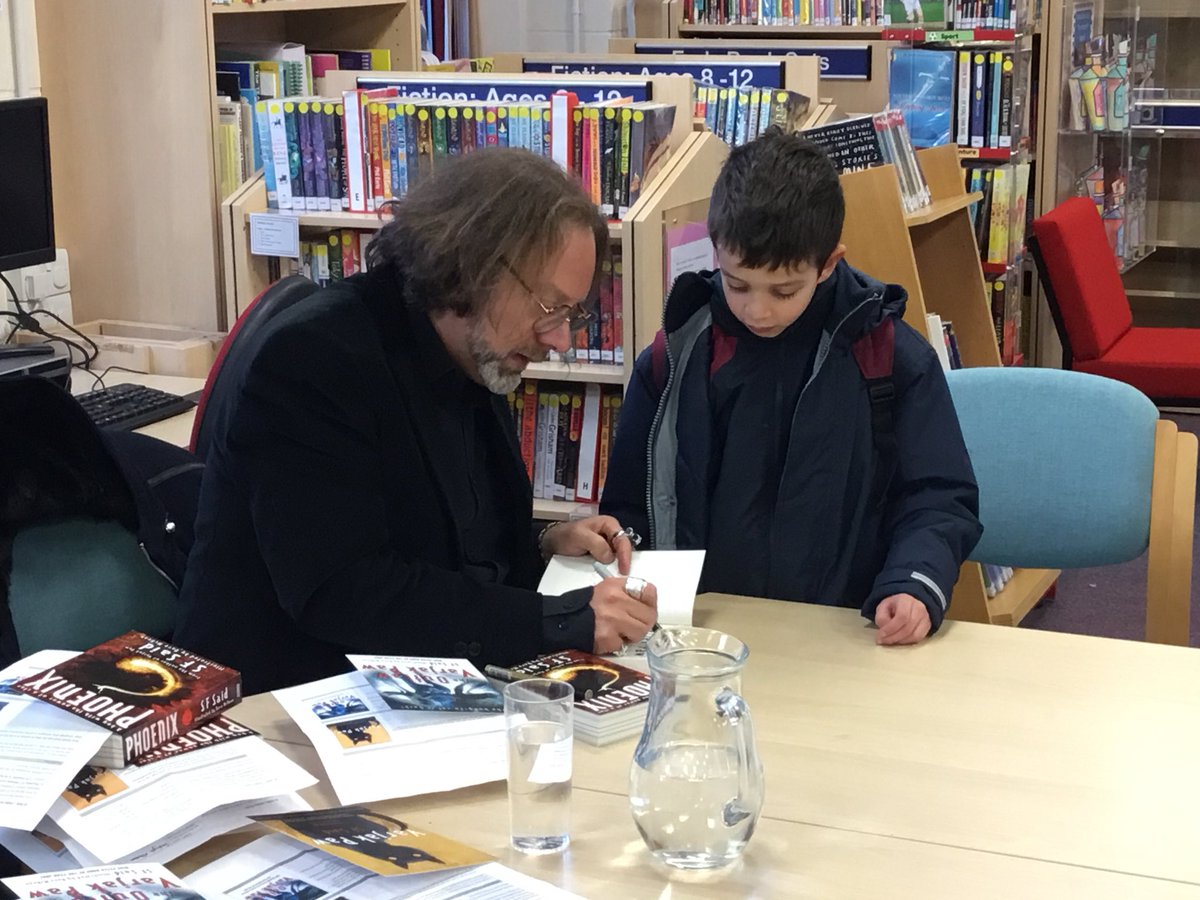 StAubynsLibrary's tweet photo. Our visiting author @whatSFSaid certainly had a lot of signing to do last week ๐ as well as having the daunting task of cutting our #10thAnniversary cake! ๐ฐ Of course he did a wonderful job of both! #10YearsoftheLibrary #GreatSchoolLibraries https://t.co/CVaTTsp2ud