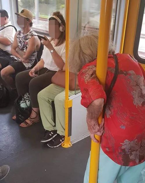 A photo of an elderly woman clinging to a railing on a packed Sydney train has divided the internet: 'No respect'. 
bit.ly/2WUOx7E