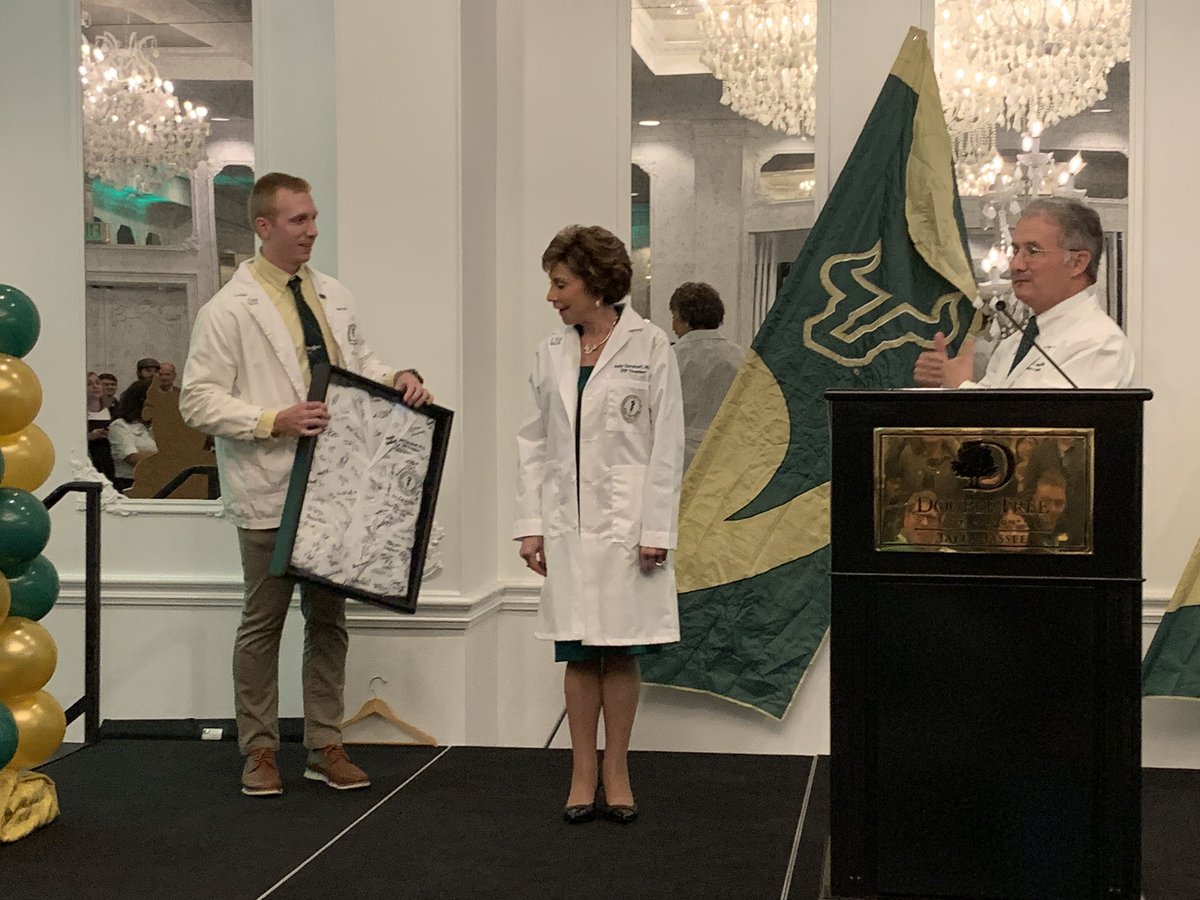 USFHealth's tweet image. “You can’t buy a white coat!” Said #USFSystem President Dr. Judy Genshaft after @Lockwood_MD and fourth year med student Patrick Mullen presented her with a @USFHealthMed white coat. #usfdatc #makinglifebetter