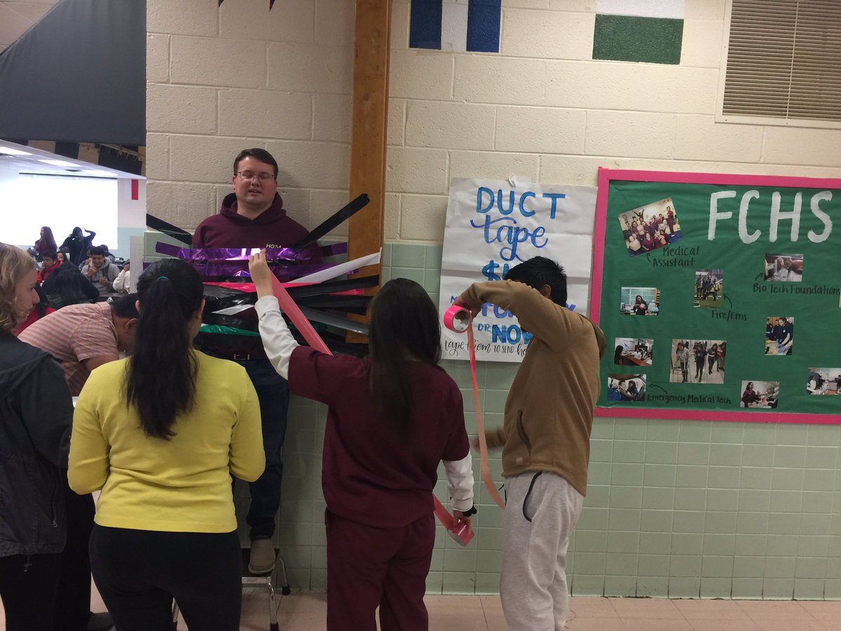 Students <a href="/FallsChurchHS/">Falls Church HS</a> are duct taping Academy Administrator <a href="/FCPS_McGreevy/">Bill</a> to the wall as a fundraiser for <a href="/HOSAfallschurch/">HOSA Falls Church Academy</a> <a href="/fcacad/">Falls Church Academy</a>