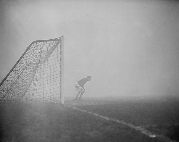 Arsenal goalkeeper Jack Kelsey peers into the fog, searching for the ball. The game was eventually stopped, Highbury, 1954.