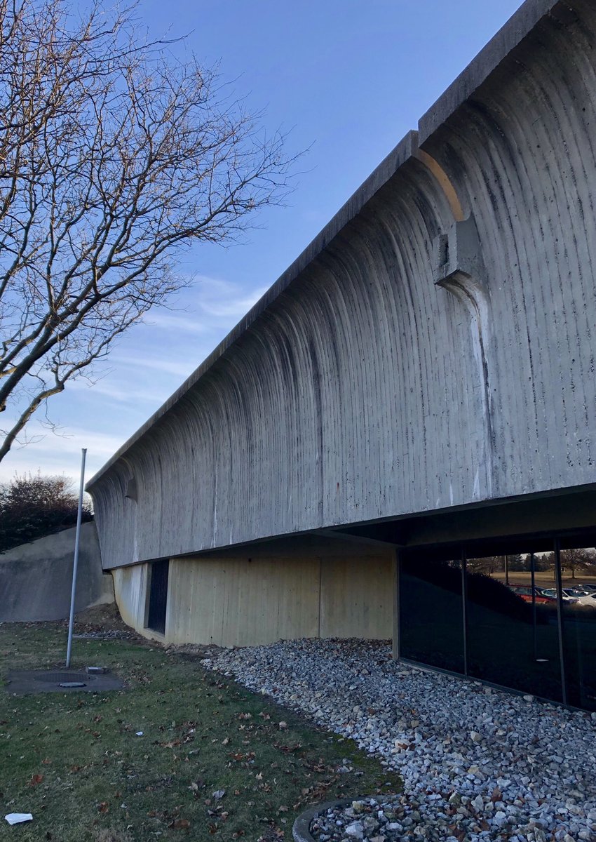 The floating library mass is clad in Ohio grain silo tile, while the mounded site references the Native American earthworks found throughout the state.