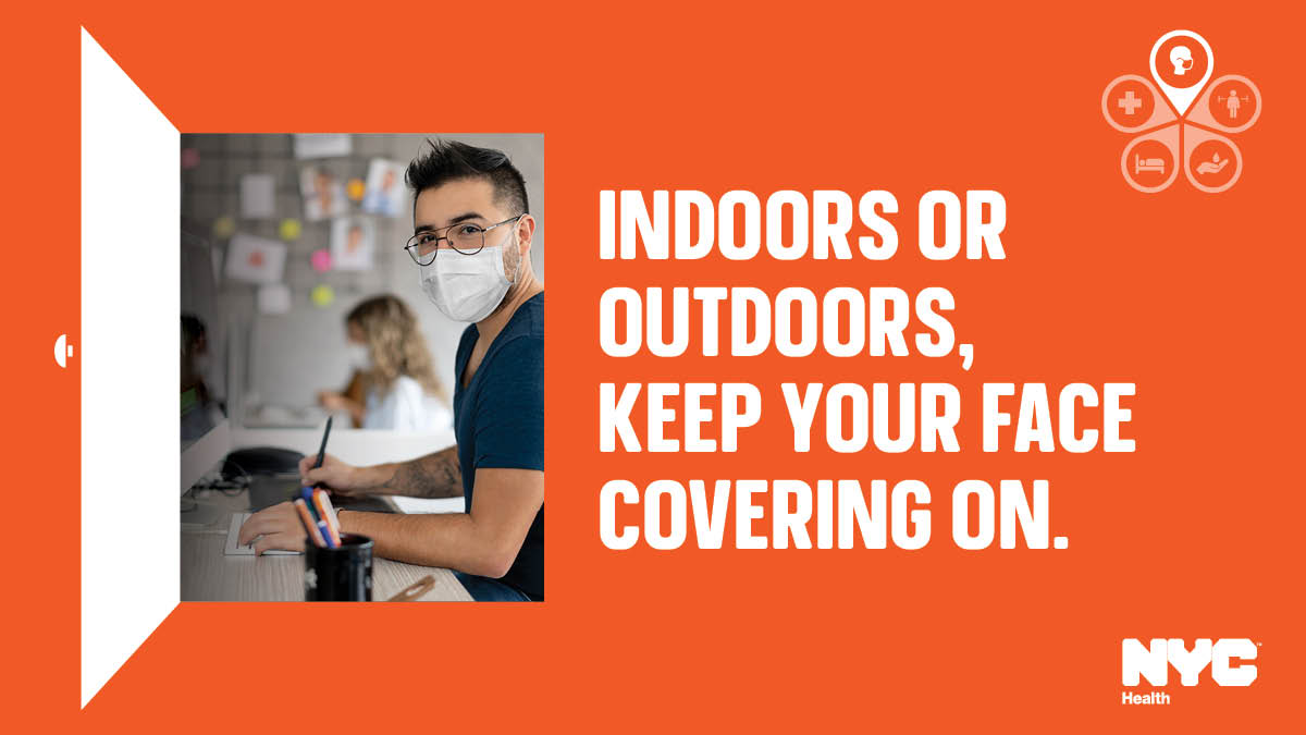 An Asian man wears glasses and a face mask while working at his desk. Text reads: Indoors or outdoors, keep your face covering on.