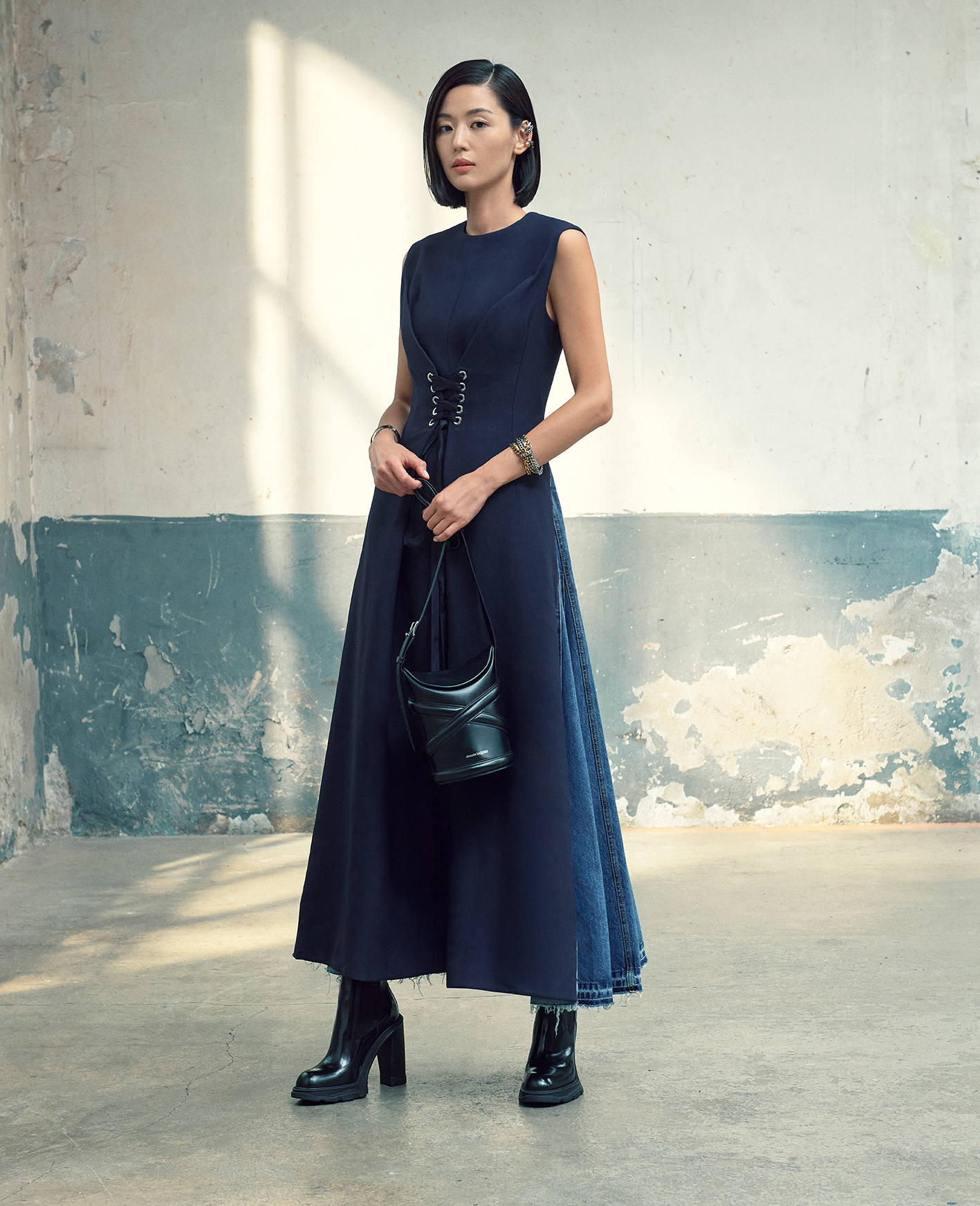Alexander McQueen on X JunJiHyun wearing a McQueenAW21 navy compact wool felt and lake blue washed denim pieced dress with laced silver metal eyelets. Worn with Tread heeled Chelsea boots and the