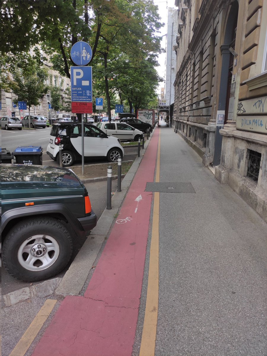 Zagreb, een stad met mooie gebouwen en waar de fiets 0 prioriteit heeft. 3 rijbanen met aan beide kanten parkeren  voor de auto. 1,5 meter stoep en 50cm fietsstrook op de stoep voor de fiets, waar ook steigers op staan en auto's half op parkeren #werkaandewinkel