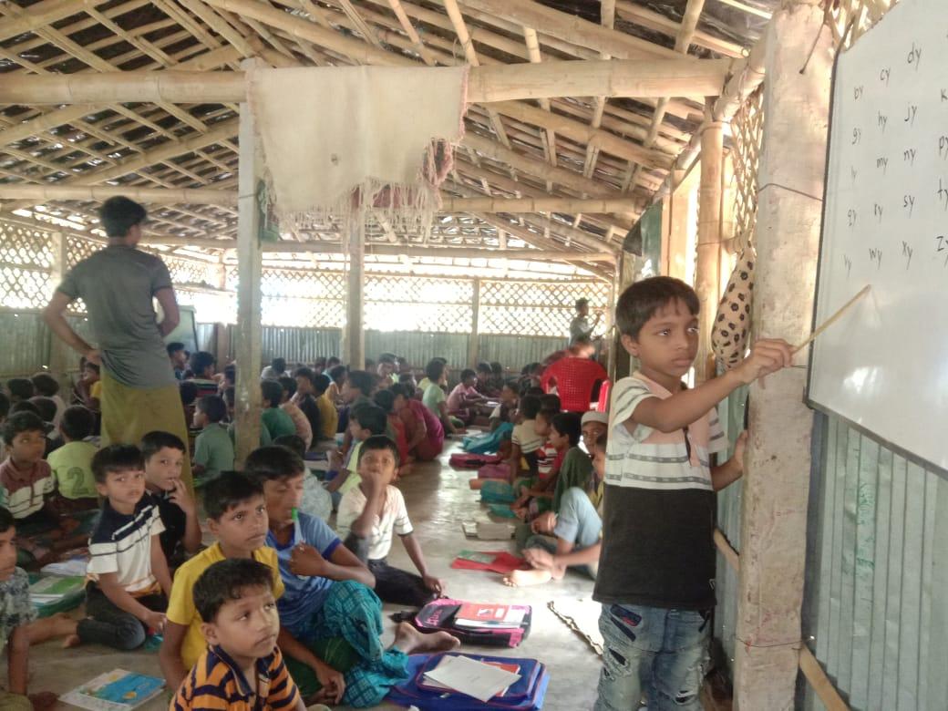 TechnicalShabb3's tweet photo. #DRFS teachers are teaching more than 300 students on the whiteboard only without any books except note books. Despite not having any school used materials, students are attending class longingly to learn Myanmar curriculum. This is how #Rohingya students are learning in BD camp. https://t.co/loSJ0U1fHC