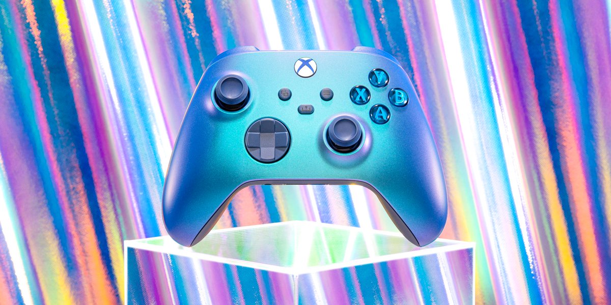 Aqua Shift Xboxkontroll vilar på en klar kub, med en krusande flerfärgad blank bakgrund.