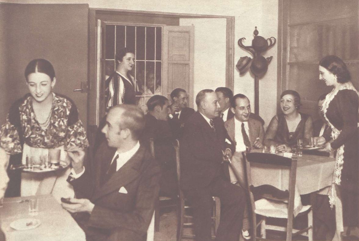 La actriz Carola Fernán Gómez, de pie y junto a la ventana, era la madre de #FernandoFernánGómez. Aquí aparece en 1933, en un restaurante de #Madrid que abrió, junto a otras dos actrices, en la calle de Concepción Arenal. ☕️ (El parecido con su hijo es asombroso ¿verdad?).