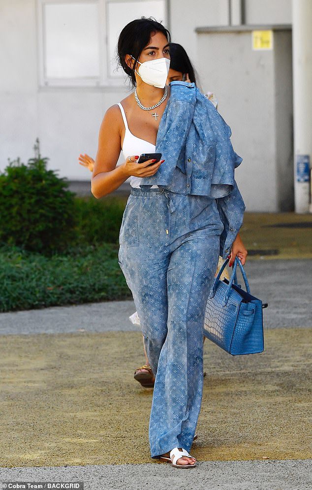 One Love on X: 🔥🔥🔥 Georgina Rodriguez puts on a busty display as she  arrived at Venice airport in a Louis Vuitton denim co-ord and Hermes  sliders and bag..  / X