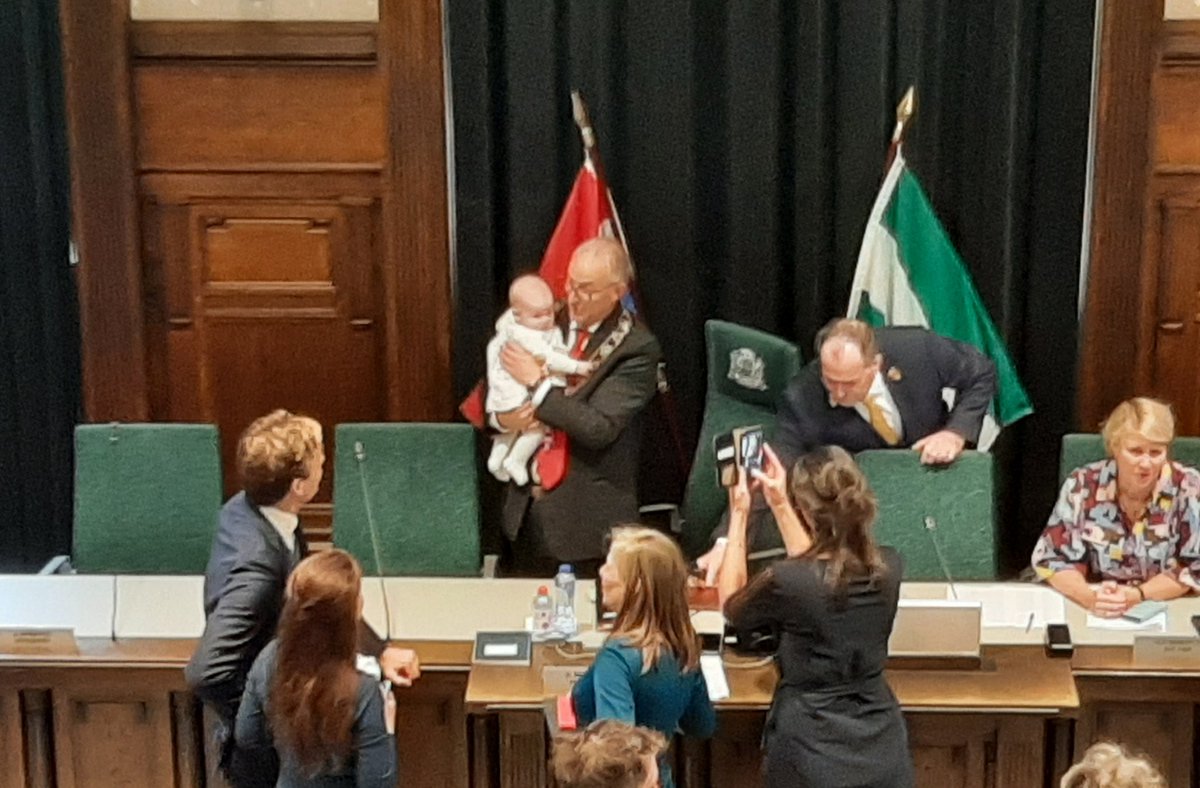 Burgemeester Aboutaleb knuffelt de dochter van Vincent Karremans. Haar vader wordt straks beëdigd als wethouder van Rotterdam.