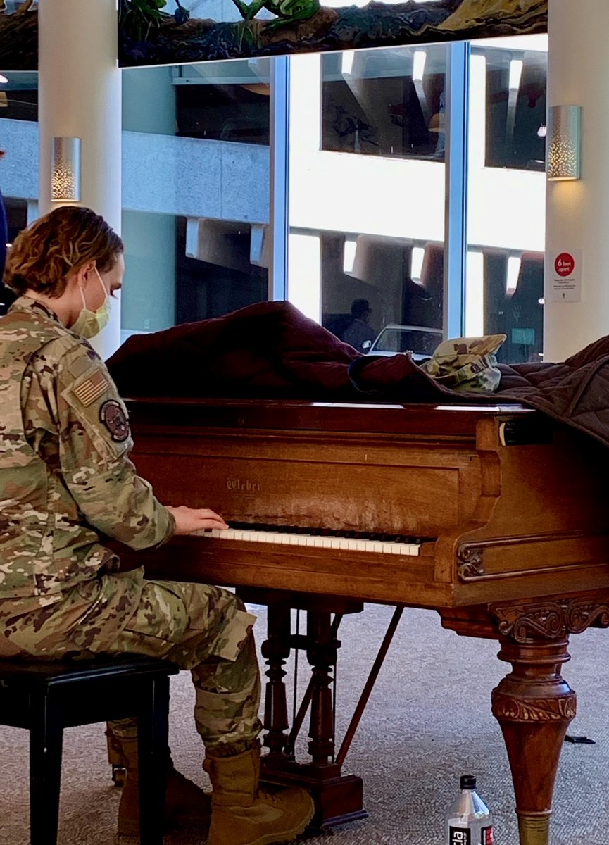 member of the National Guard sits down at a piano in the Doernbecher Children's Hospital lobby and begins to play.
