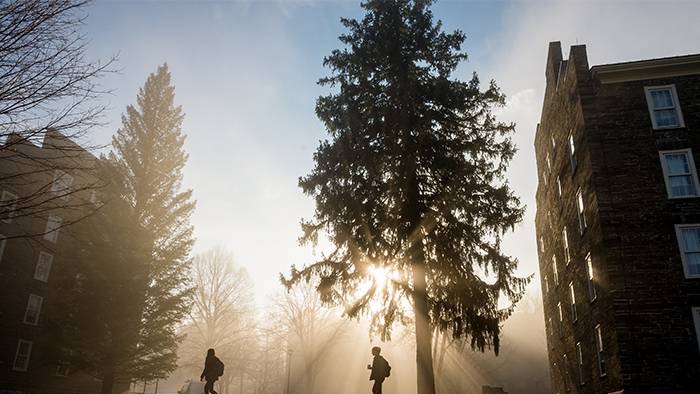 Students walk across the Colgate campus on a foggy morning.