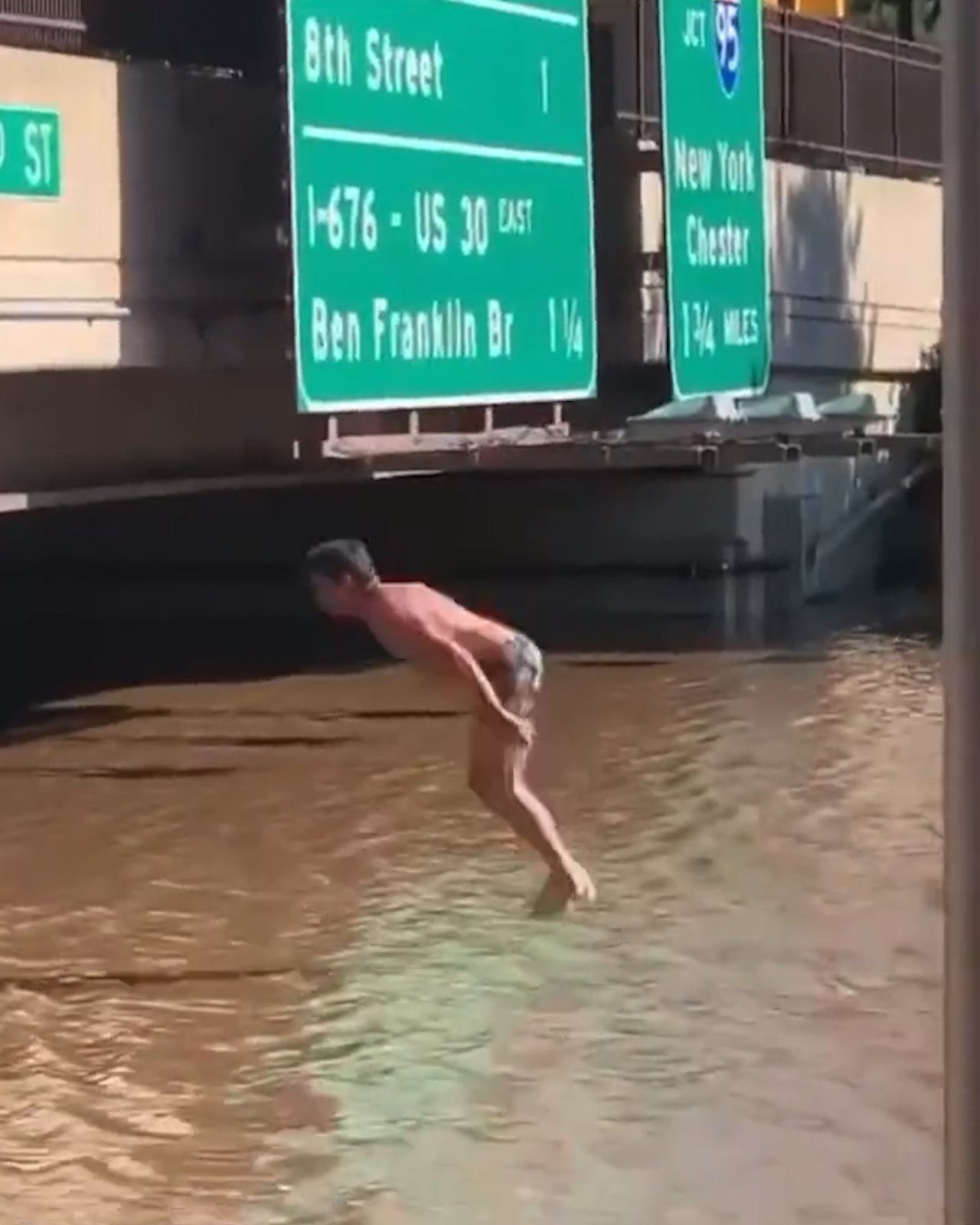 Hombre realiza saltó  en las aguas que inundan una calle (VIDEO) 