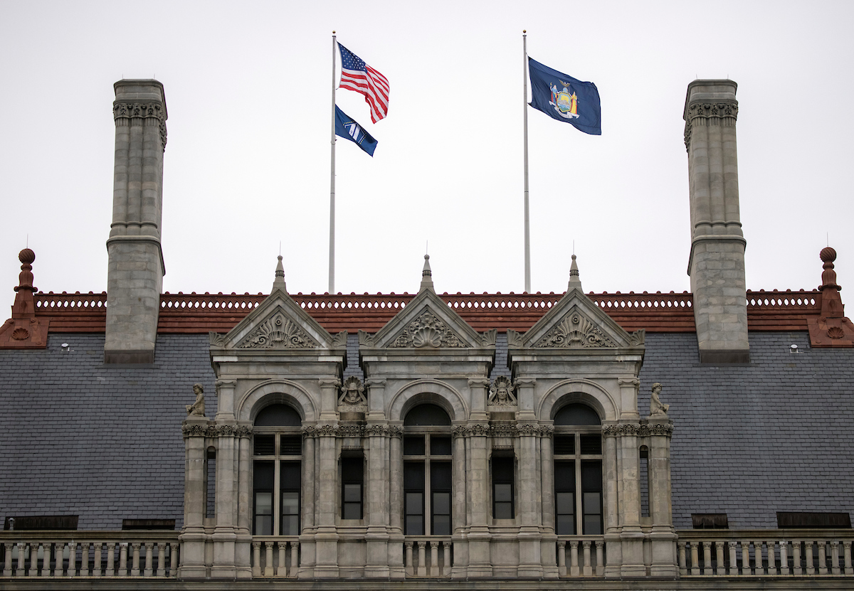 The U.S. Flag and the 9/11 Flag (left) and the New York State Flag (right) flown above the Capitol Building in Albany