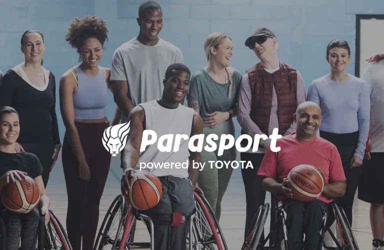 Some disabled people looking happy posing in a sports hall