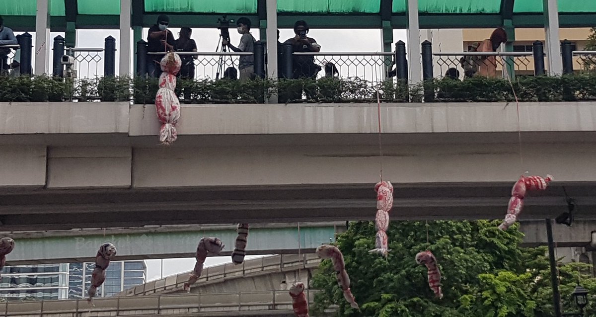 MayWongST's tweet photo. #Thailand protesters have strung up mock corpses at previous demonstrations to represent those who died from #Covid19 due to alleged government mismanagement. This time, desperation to get their message across has led them to hang a girl over walkway for a few minutes #ม็อบ6กันยา https://t.co/aYScMKwecr