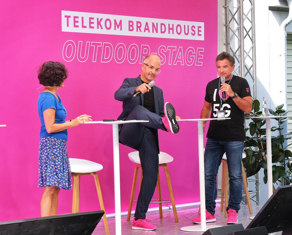 Christoph Maria Herbst zeigt die neueste 🍂-Schuhmode für Sneaker in der Farbe Magenta! Auf der Bühne des „Telekom Brandhouse #Homeoffice“ auf der #DigitalX in Köln | #telekomwall