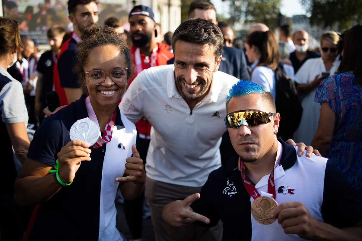 Photo de Tony Estanguet avec 2 athlètes paralympiques qui montrent leur médaille.