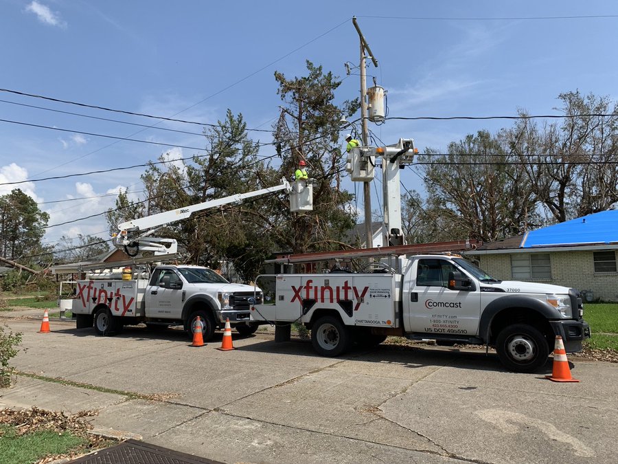 Xfinity technicians using cherry pickers on their service vehicles.