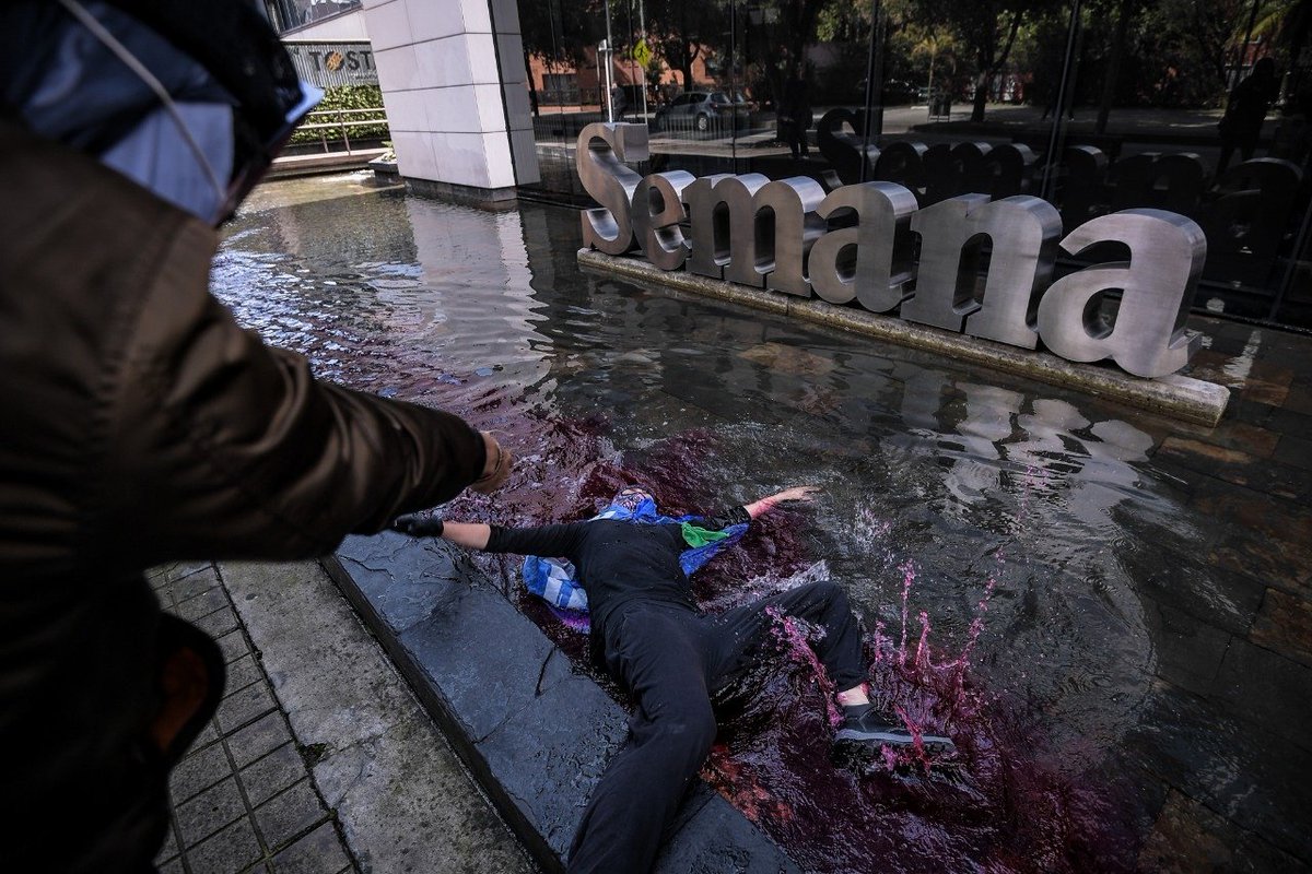 photomauricio's tweet photo. En la décima jornada del Paro Nacional manifestantes realizaron un performance frente al edificio de la @RevistaSemana, para protestar contra la manipulación de la información, la violencia y la represión hacia la protesta social.

#SOSColombia #ParoNacional  @EscudosAzules https://t.co/WSPsUo89i6
