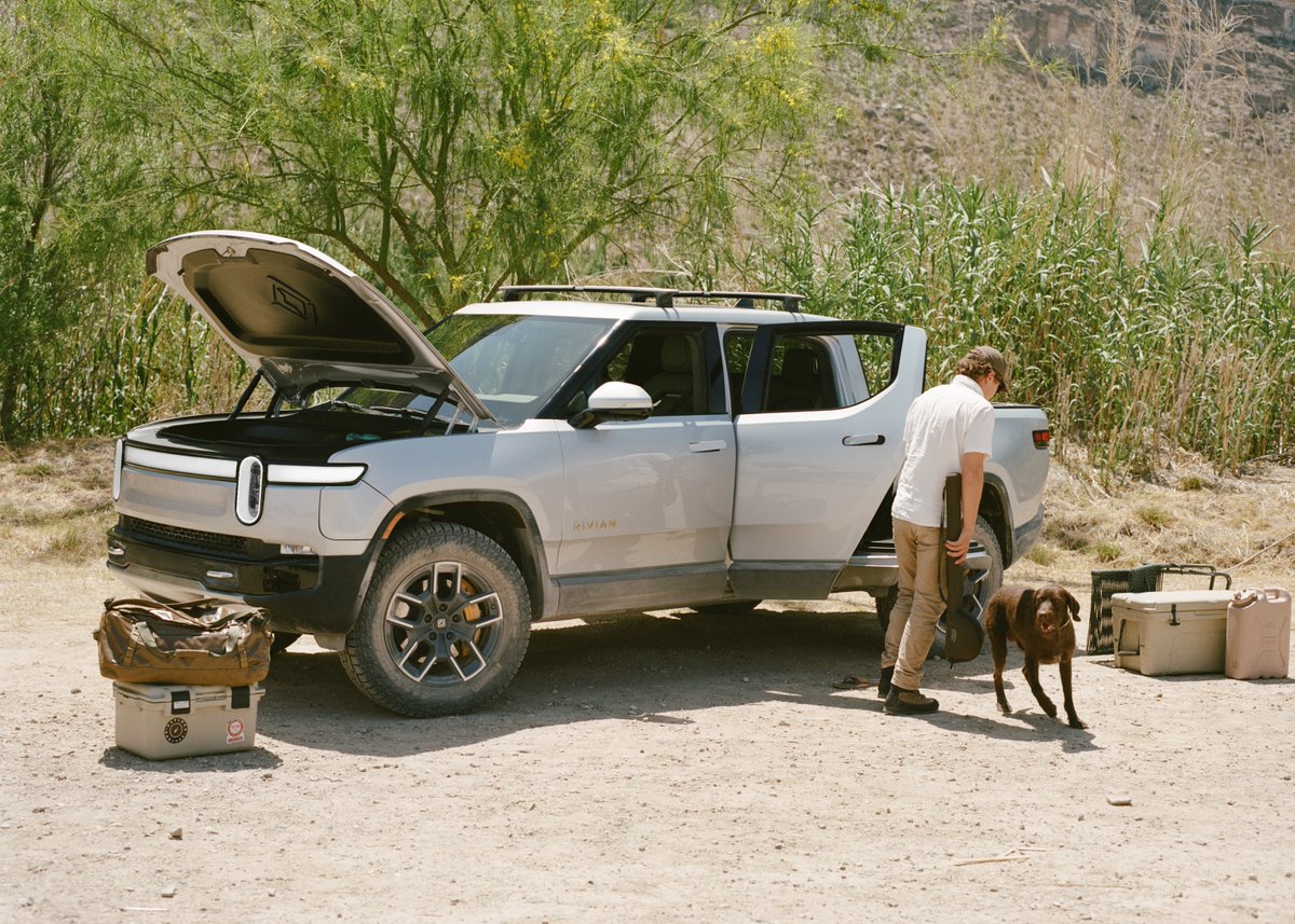 Rivian's tweet image. Take a closer look at the R1T on our blog. We’re walking you through everything from the big stuff (front trunk and bed size) to the nitty gritty (a hideaway trailer hitch and where the power outlets live) and more. Head to the blog. rivn.co/3tngGDm
