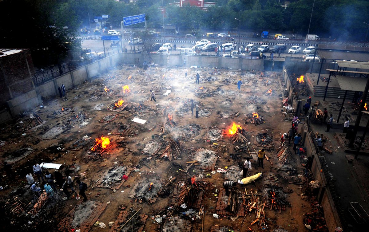 Burning funeral pyres are seen during a mass cremation for those who died from the COVID-19 at a crematorium in Delhi, India, which recorded 350,000+ new coronavirus infections on Monday. Partha Sarkar / Getty