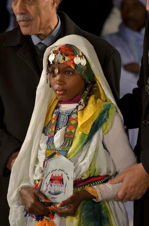 Accessories that are colorful (like the sash/forehead band here) are said to be indicative of what was imported from sub-Saharan cultures (the case for Algeria in general) when Black populations became a part of North African society