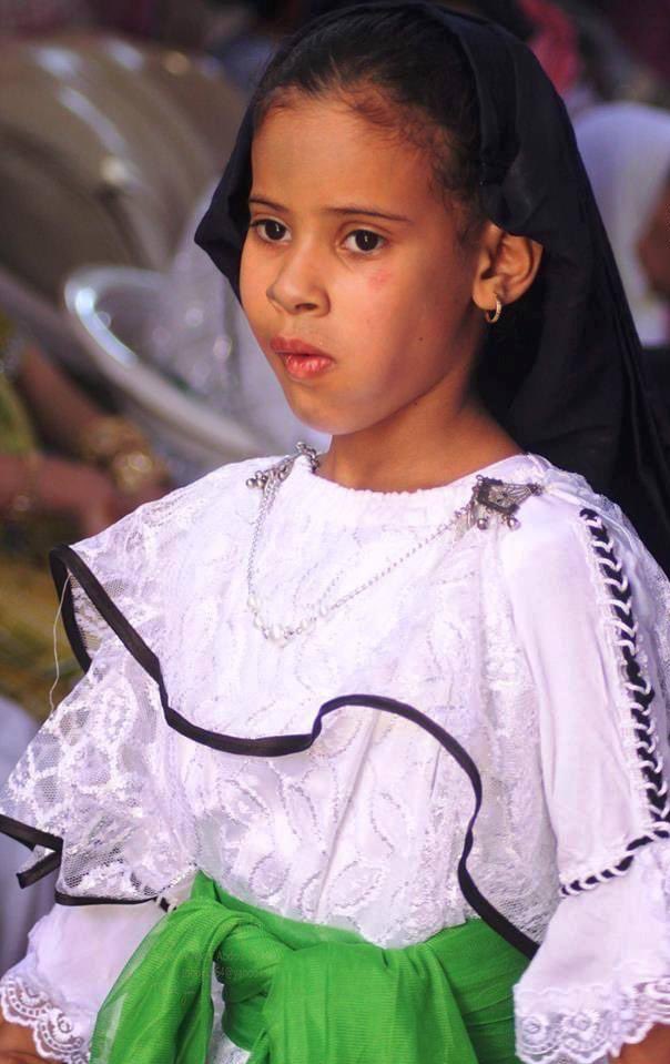 This dress is traditionally called roba el jamma (روبة الجمة) which specifically refers to the under-piece. In Aoulef, the belt around the waist is yellow/orange whereas in Tidikelt/In Salah it is in lime green.