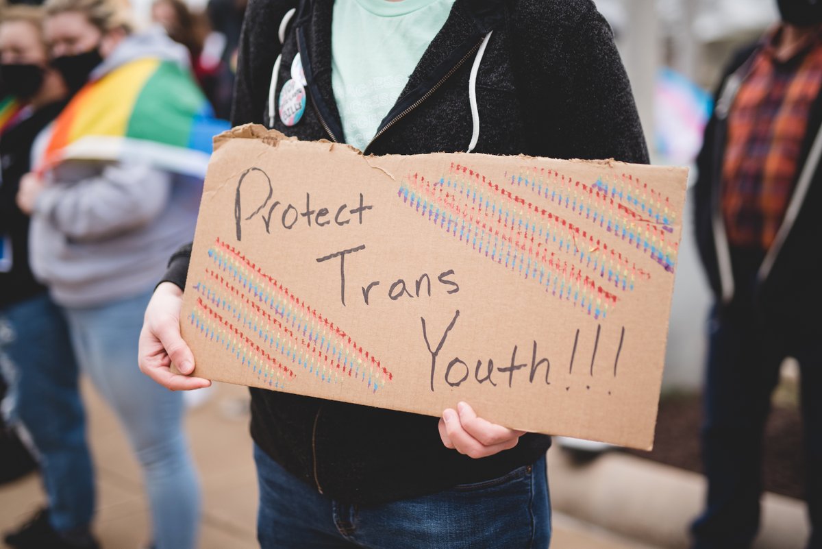 Close-up photo of a protest sign that reads "Protect trans youth!"
