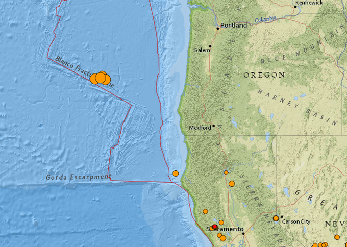 Real time earthquake map showing orange circles  in a blue ocean where earthquakes occurred off the Oregon coast.