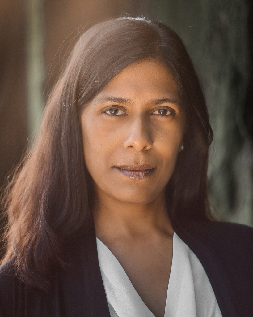 Headshot of Lolita Chakrabarti, who has long brown hair and a white shirt.