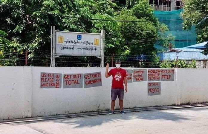 Myanmar_Now_Eng's tweet image. In red paint on the walls outside the Myanmar Oil and Gas Enterprise (MOGE) in Yangon, a protester calls for int'l sanctions against the junta-run entity, as well as the withdrawal of oil &amp;amp; gas giants such as Total, Chevron &amp;amp; Petronas for continuing to fund the regime.