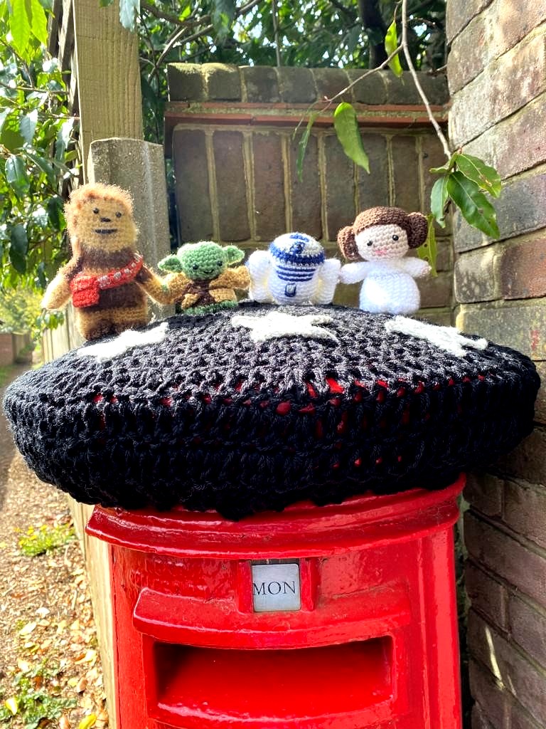 Cute little knitted plush figures of Chewbacca, Yoda R2-D2 and Princess Leia atop a postbox in Surrey!