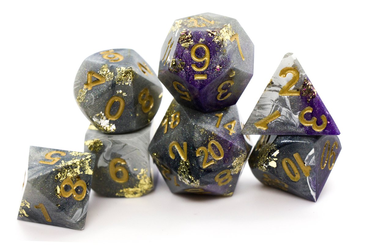 Handmade resin dice in different shades of grey and white with purple swirls, gold leaf foil and gold ink for the numbers, very minor flaws on some of the facets that face the lid --> 70 Euro excluding shipping.