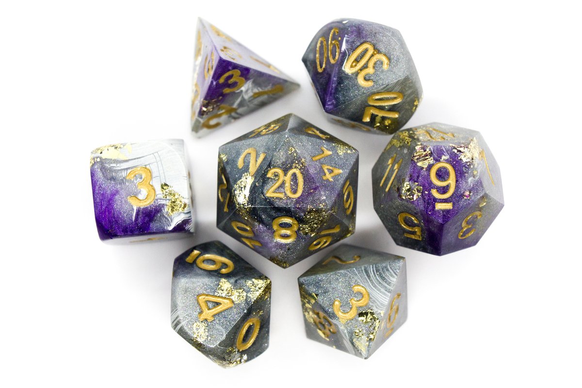 Handmade resin dice in different shades of grey and white with purple swirls, gold leaf foil and gold ink for the numbers, very minor flaws on some of the facets that face the lid --> 70 Euro excluding shipping.