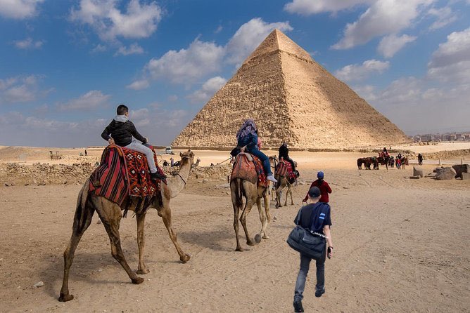 GREAT PYRAMID OF GIZA — He looks so small next to the Camels 