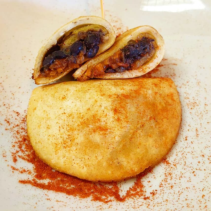 Hay que probarlo sí o sí! Os presento nuestra nueva empanada vegana de nuestro chef Danny de Venezuela! De de harina de maíz con pabellón (frijoles) y tajada de plátano, riquísimas. 😋