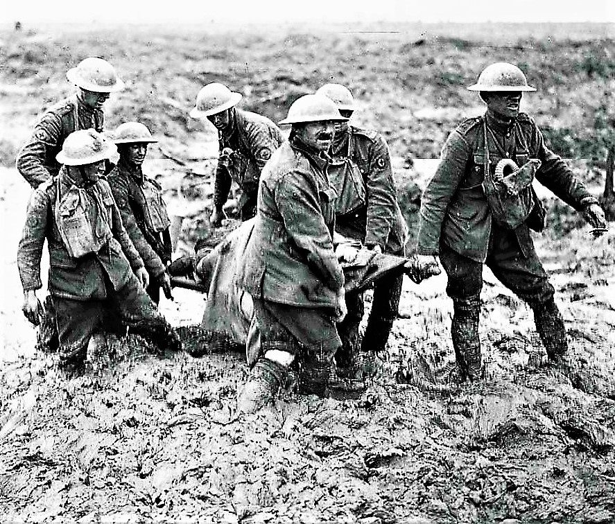 The photograph is of a team of stretcher-bearers struggling through deep mud to carry a wounded man to safety near Boesinghe, on the 1st of August 1917, in the Battle of Pilckem Ridge, which was the opening attack of the Third Battle of Ypres (also known as the Battle of