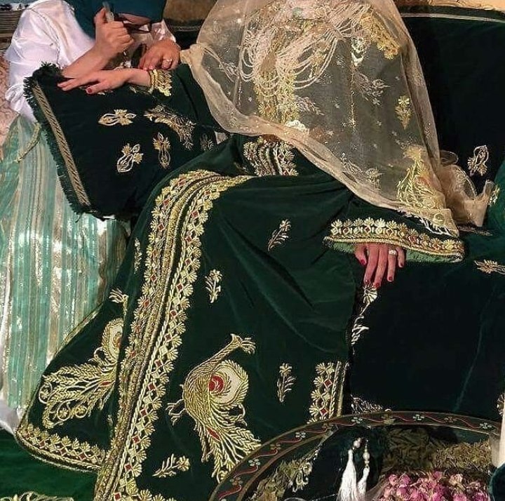 Le caftan 𝑵𝒕𝒂𝒂Caftan de velours de soie souvent noir ou vert foncé, brodé au fil d'or (sqalli)Ce caftan tire son nom de la broderie (tarz) Ntaâ, caractérisée par l'apparition de motifs floraux et/ou de paonDe nos jours, la robe est portée par la mariée le jour duhenné