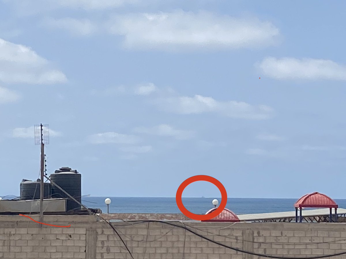 WhateverInGaza's tweet photo. Zoom in here - Israeli warship from our window. Seconds after I took it, it actually fired one projectile nearby. #GazaUnderAttack https://t.co/It0ERMXvvO