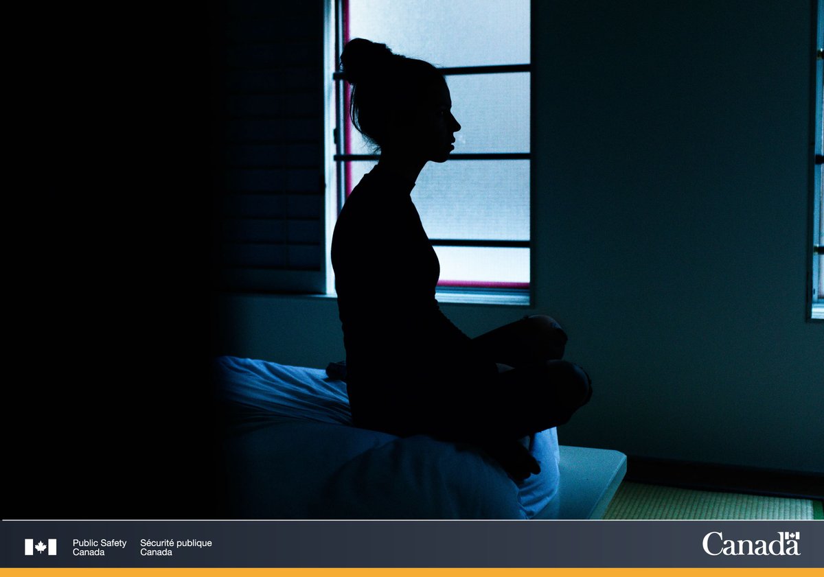 Silhouette of a woman sitting on a bed.