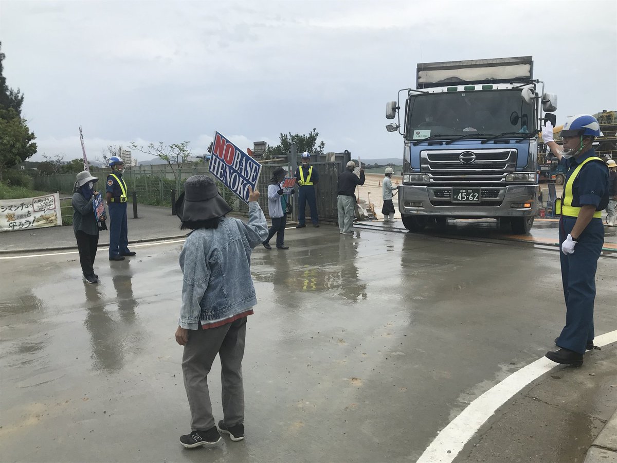 times_henoko's tweet photo. 5月10日午後1時半ごろ、名護市安和の琉球セメント桟橋前では、辺野古新基地建設用の土砂を積んだダンプカーに向けて、市民らがプラカードを掲げ抗議の声を上げています。#安和　#辺野古　#沖縄 https://t.co/3vbzVtYMhw